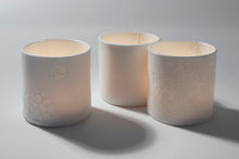 Charger l'image dans la galerie, Collection "Ombre et lumière" de Marianne Chemla (m céramique) Lampions en porcelaine translucide avec dessins incrustés qui se révèlent une fois le lampion allumé. Un objet délicat et fonctionnel qui sème un peu de magie lumineuse! Disponible en 3 motifs : lignes d’horizon, topographie et lotus. Fait à la main, chacun est unique. À utiliser avec une bougie chauffe-plat.  Blanc neige avec glaçure transparente à l’intérieur. Porcelaine translucide cuite à 2232 °F.