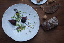 Charger l'image dans la galerie, Collection Traces de Marianne Chemla (m céramique) Un saladier minimaliste et organique qui évoque une feuille ou un coquillage. Sa forme est créée par le mouvement de la galette de porcelaine qui tombe dans le moule. Chaque saladier est unique, fait à la main et texturé avec les doigts.  Blanc doux avec glaçure transparente. Porcelaine cuite à 2232 °F.