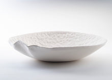 Charger l'image dans la galerie, Collection Traces de Marianne Chemla (m céramique) Un saladier minimaliste et organique qui évoque une feuille ou un coquillage. Sa forme est créée par le mouvement de la galette de porcelaine qui tombe dans le moule. Chaque saladier est unique, fait à la main et texturé avec les doigts. Blanc doux avec glaçure transparente. Porcelaine cuite à 2232 °F.