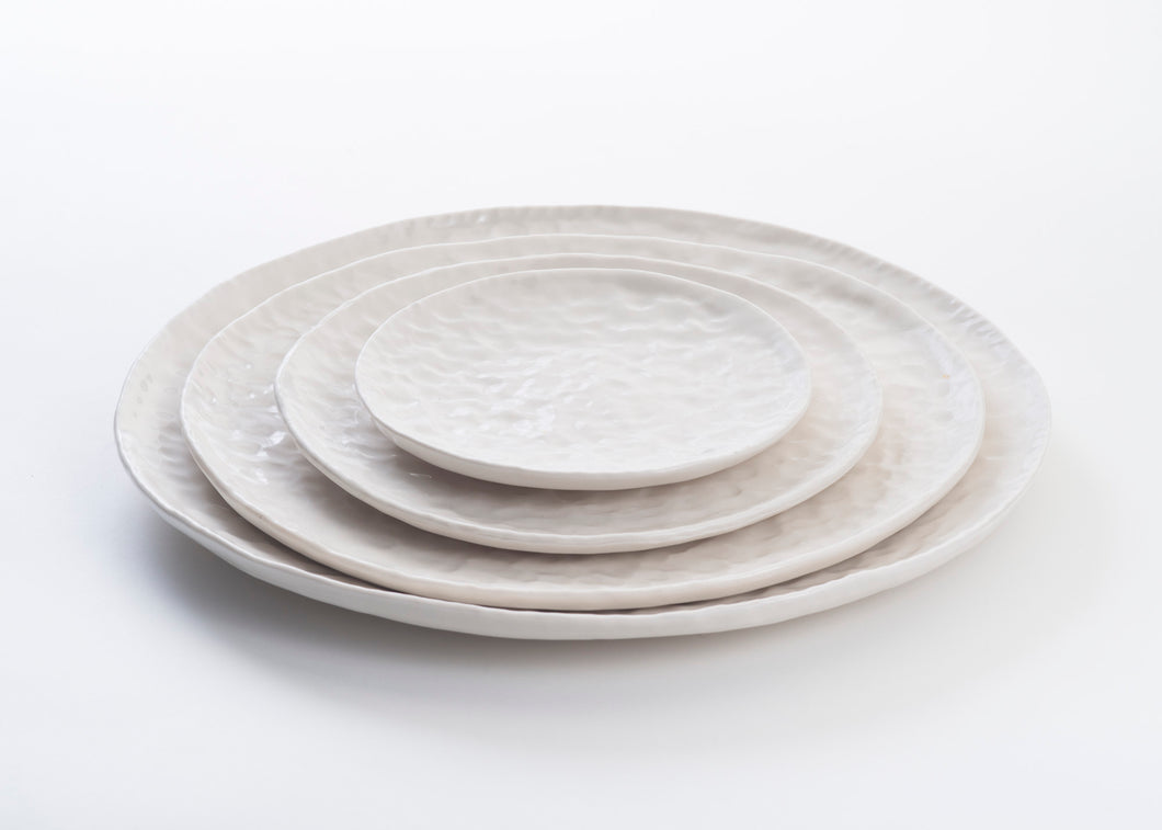 collection traces de Marianne Chemla (m-céramique): Assiettes offertes en 4 formats. Fait à la main et texturé avec les doigts.  Blanc doux avec glaçure transparente. Porcelaine cuite à 2232 °F.